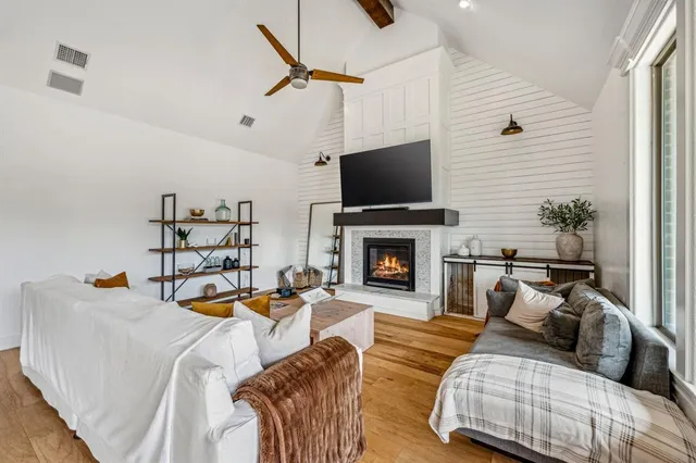 a living room with furniture a flat screen tv and a fireplace