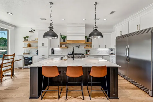 a kitchen with sink refrigerator dining table and chairs