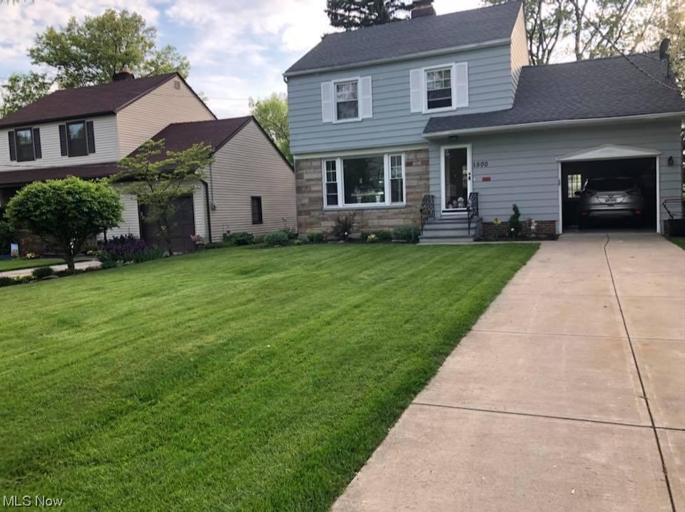 View of front of property featuring a garage and a front lawn