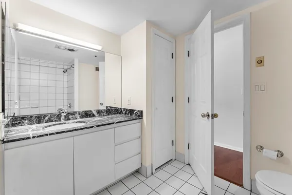 a bathroom with a sink and mirror with toilet