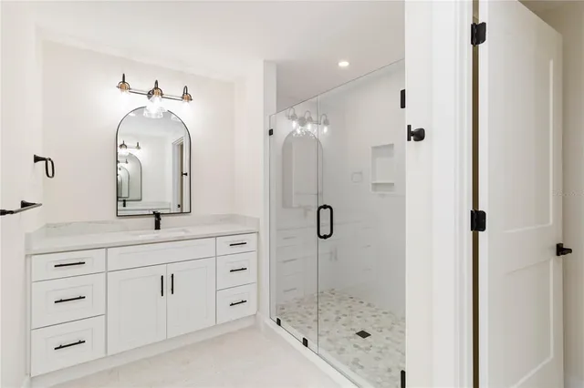 a bathroom with a double vanity sink mirror and shower