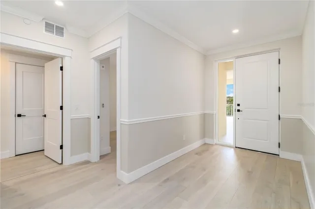 an empty room with wooden floor & cabinet and a window
