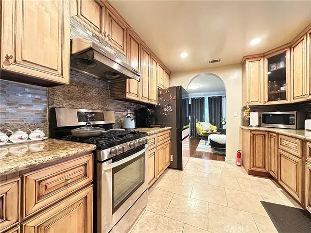 a kitchen with stainless steel appliances granite countertop a stove and cabinets