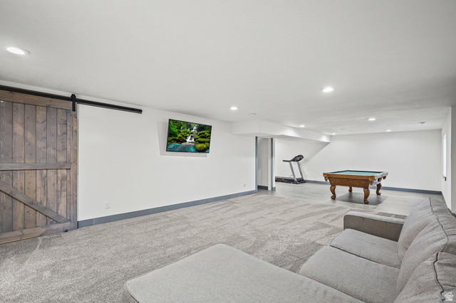 1588 West Rim Rock Drive Stockton, UT 84071 - Photo 29 of 61 Spacious recreation room featuring recessed lighting and a rustic wood-finish barn door