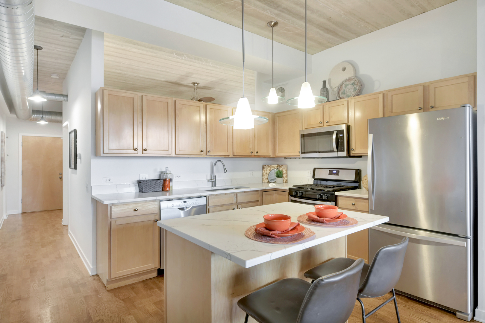 3260 North Clark Street, Unit 407 Chicago, IL 60657 - Photo 5 of 18 a kitchen with a refrigerator a stove a sink dishwasher and white cabinets with wooden floor