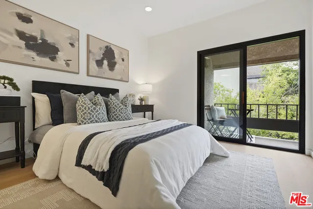 a bedroom with a large bed and a potted plant