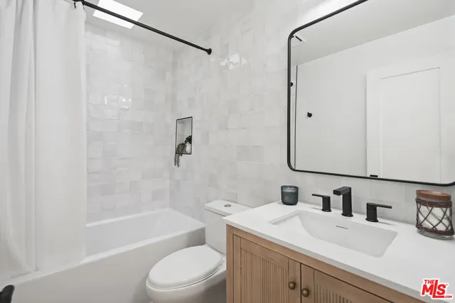 a bedroom with a large bed and a potted plant