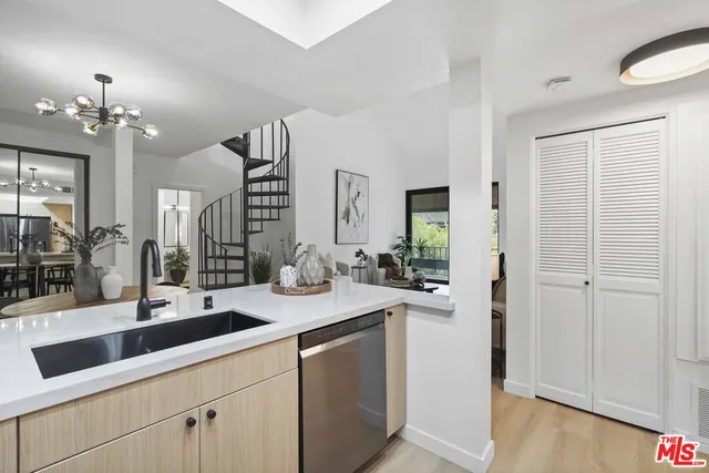 a living room with furniture a rug potted plant and a large window