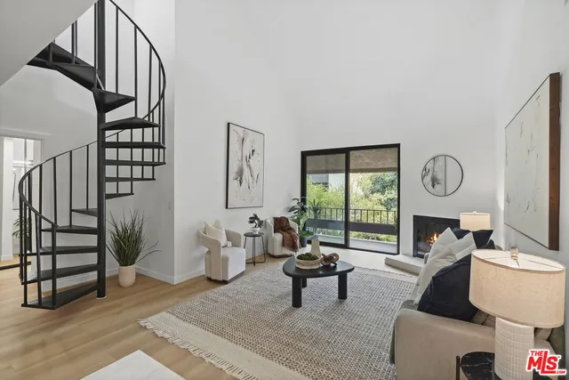 a living room with furniture a large window and a fireplace