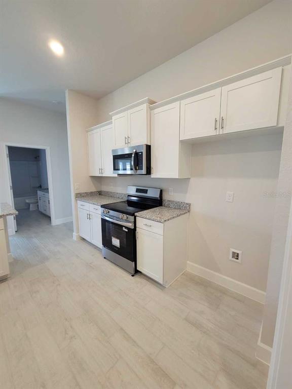 4626 Southwest 103rd Street Road Ocala, FL 34476 - Photo 12 of 29 a kitchen with a sink a stove and cabinets