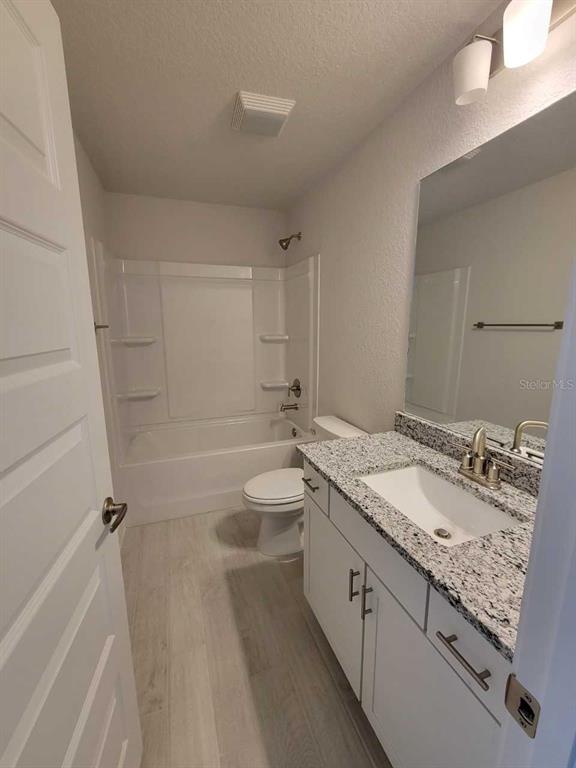 4626 Southwest 103rd Street Road Ocala, FL 34476 - Photo 25 of 29 a bathroom with a granite countertop sink a toilet and bathtub