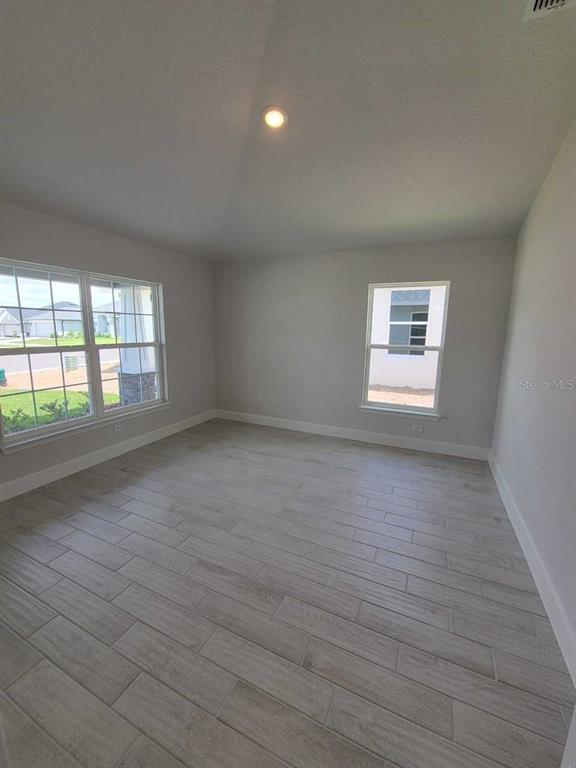 4626 Southwest 103rd Street Road Ocala, FL 34476 - Photo 5 of 29 an empty room with wooden floor and windows