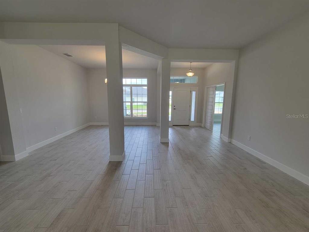 4626 Southwest 103rd Street Road Ocala, FL 34476 - Photo 7 of 29 an empty room with wooden floor and windows