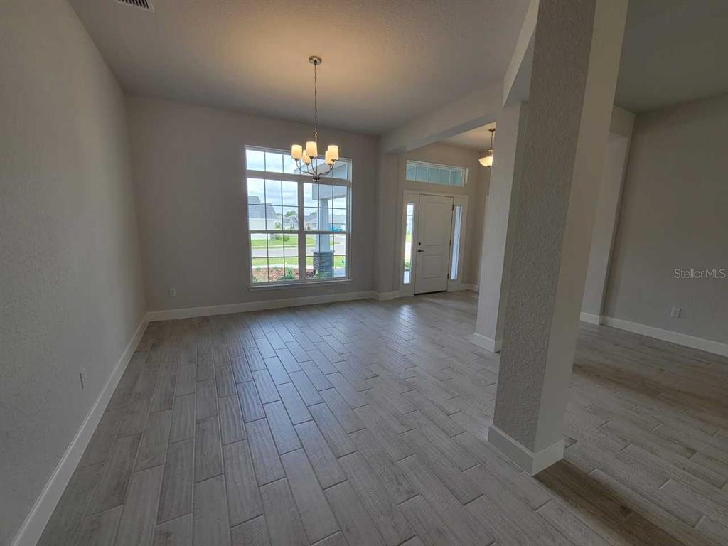 4626 Southwest 103rd Street Road Ocala, FL 34476 - Photo 8 of 29 an empty room with wooden floor and windows