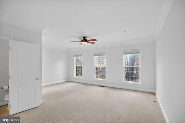 a view of a room with a ceiling fan and window