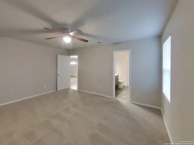 a view of an empty room with a ceiling fan