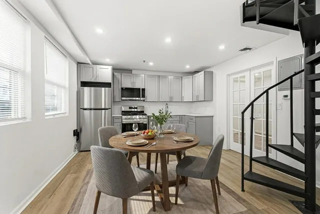 a view of a dining room with furniture and a refrigerator