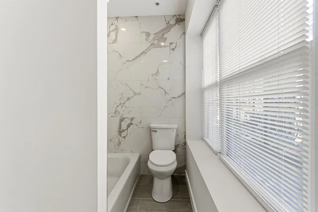 a bathroom with a toilet and a shower