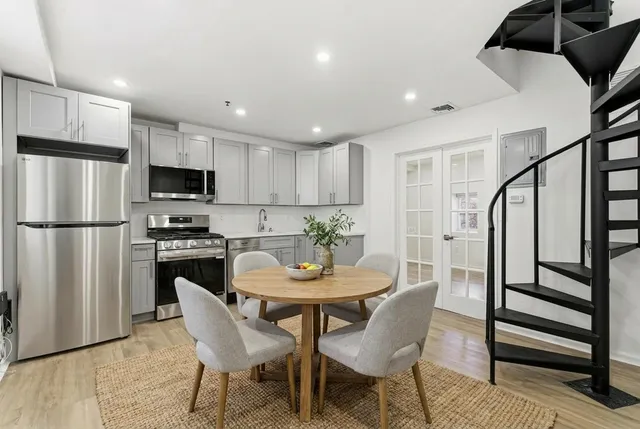 a view of a dining room with furniture a kitchen and chandelier