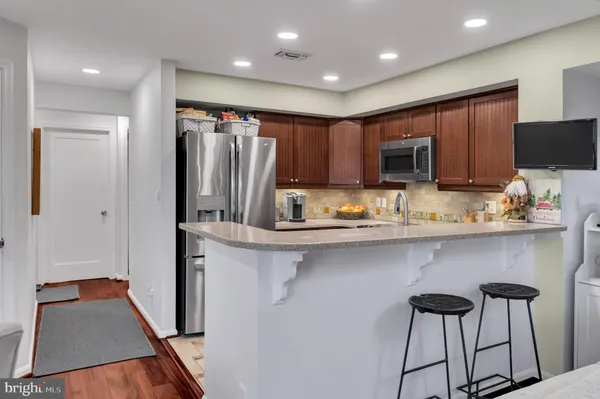 a kitchen with granite countertop a sink refrigerator and microwave
