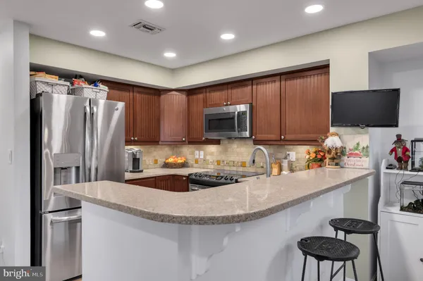 a kitchen with stainless steel appliances granite countertop a stove microwave and sink