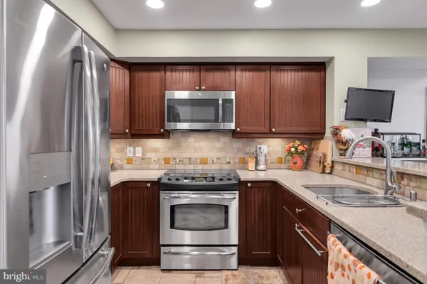a kitchen with stainless steel appliances granite countertop a refrigerator and a sink