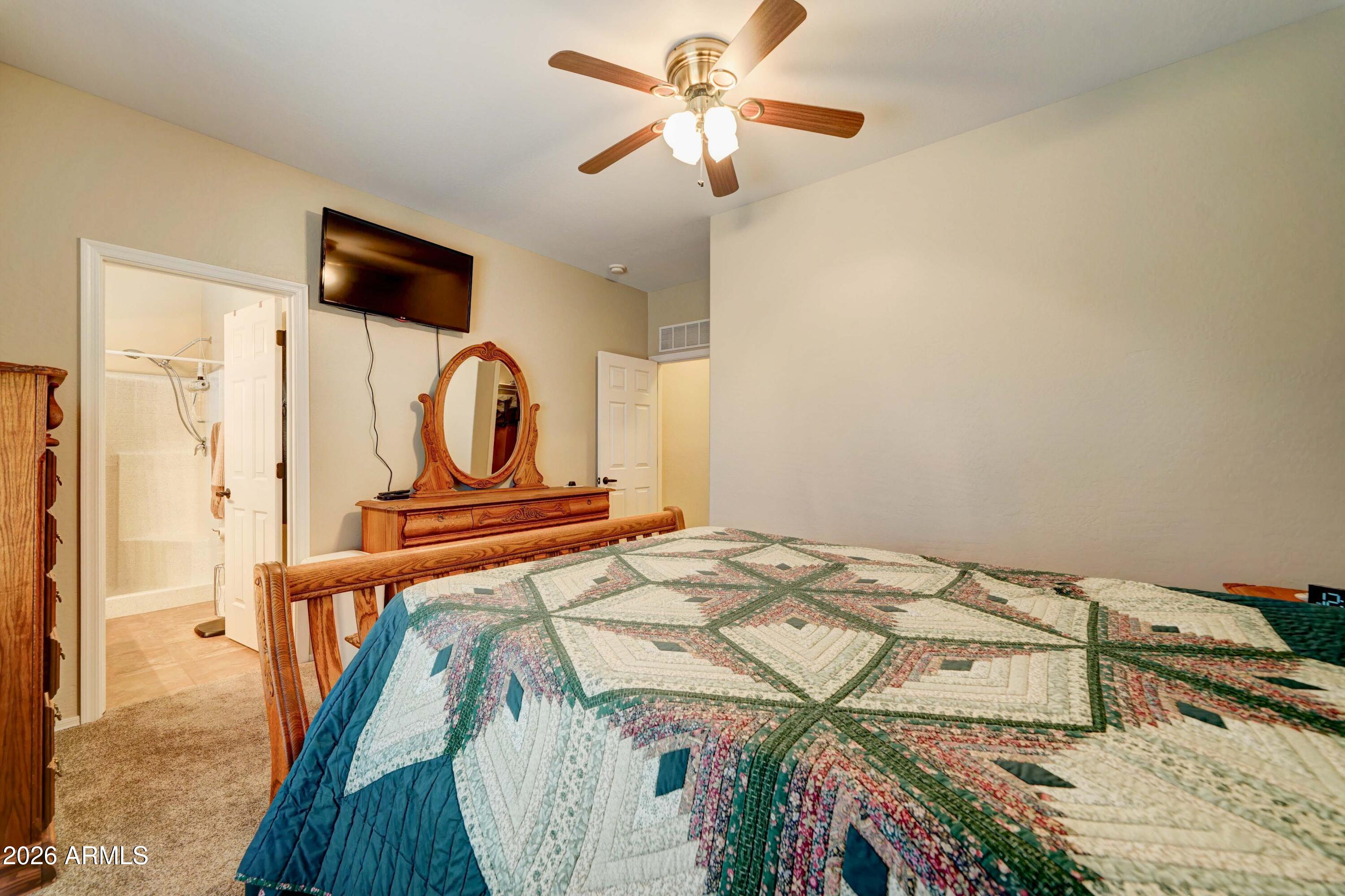 2101 South Meridian Road, Unit 164 Apache Junction, AZ 85120 - Photo 14 of 56 a bedroom with a bed and a chandelier