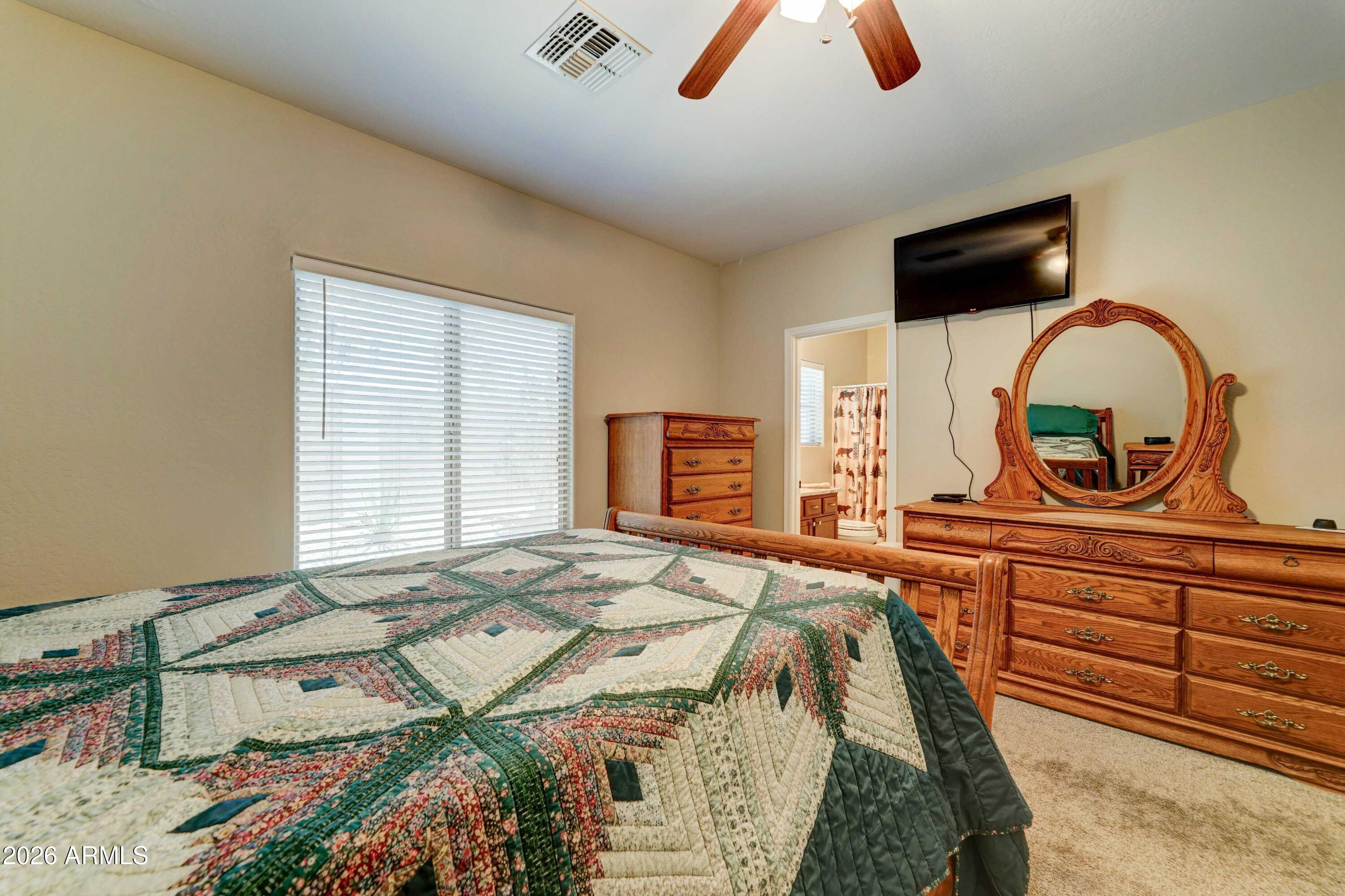 2101 South Meridian Road, Unit 164 Apache Junction, AZ 85120 - Photo 15 of 56 a spacious bedroom with a bed and a flat screen tv