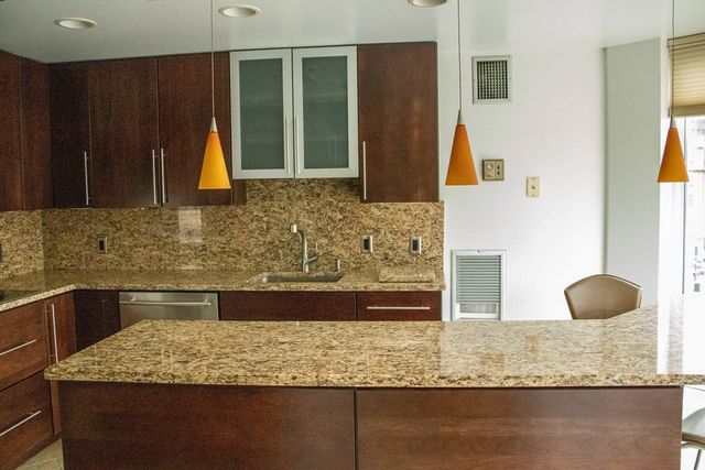 a bathroom with a granite countertop sink and a mirror
