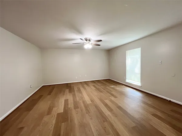 a view of a room with wooden floor and fan