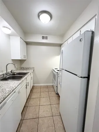 a kitchen with a refrigerator sink stove and cabinets