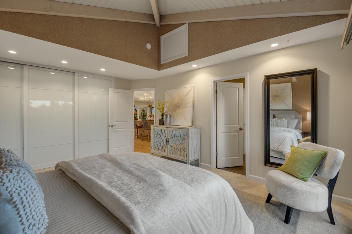 15076 Elm Park Monte Sereno, CA 95030 - Photo 40 of 68 a spacious bedroom with a bed a couch and a chandelier