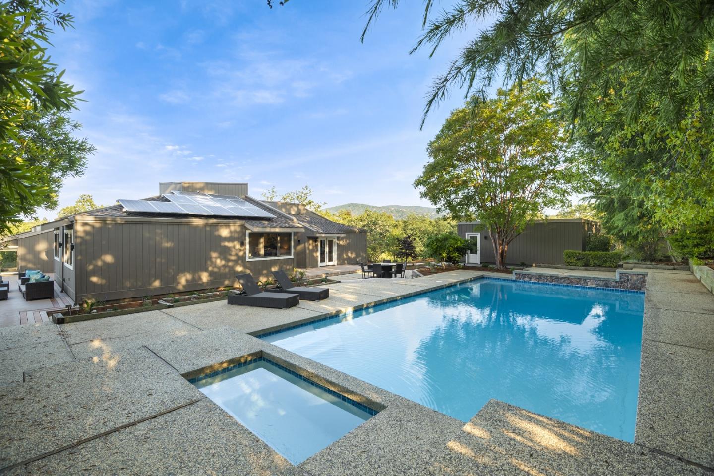 15076 Elm Park Monte Sereno, CA 95030 - Photo 49 of 68 a view of a swimming pool with lawn chairs under an umbrella