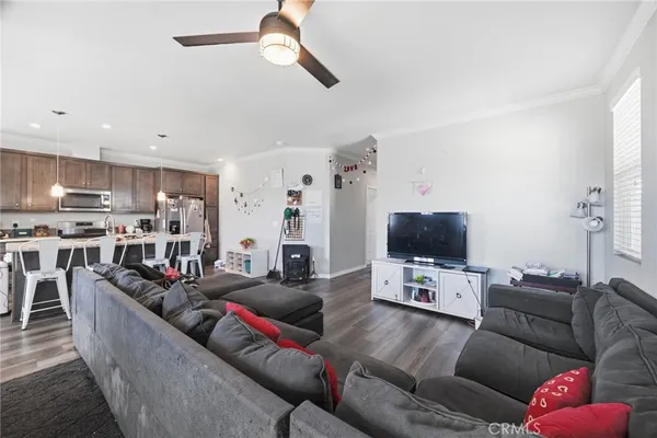 a kitchen with stainless steel appliances granite countertop a dining table chairs and white cabinets