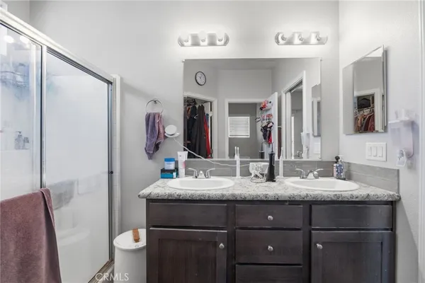 a en suite bathroom with a granite countertop sink a mirror and shower