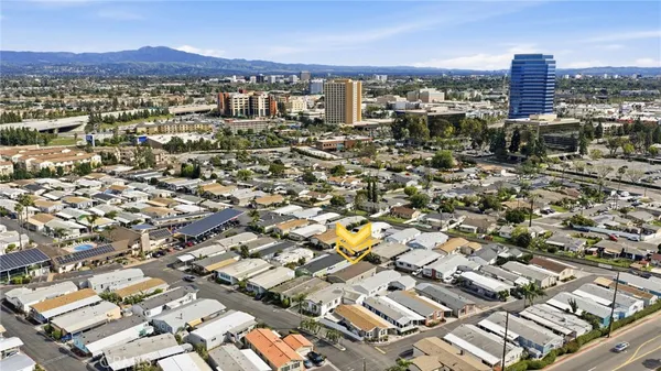 an aerial view of a city with lots of residential buildings and ocean view in back