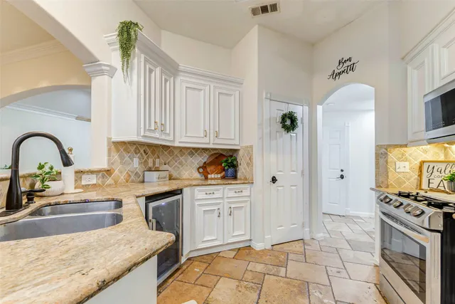 a kitchen with stainless steel appliances granite countertop a stove a sink and a refrigerator
