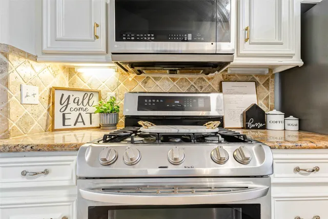 a kitchen with a stove and a white cabinet