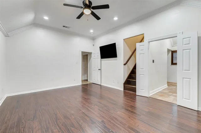 a view of a livingroom with wooden floor and staircase