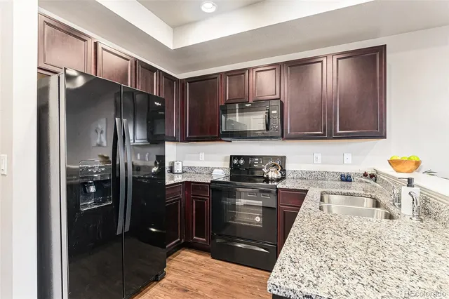 a kitchen with stainless steel appliances granite countertop a refrigerator stove and sink