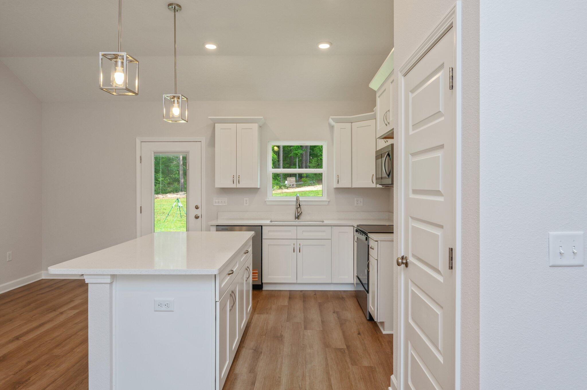 3929 Poverty Creek Road Crestview, FL 32539 - Photo 13 of 37 a kitchen with white cabinets and white appliances