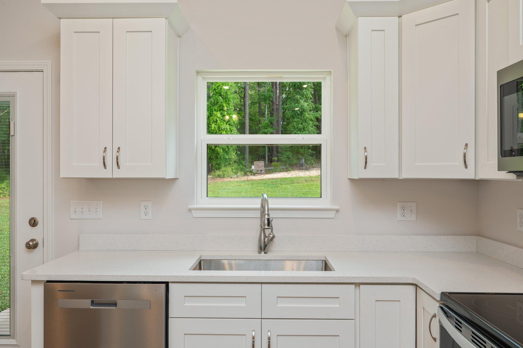 3929 Poverty Creek Road Crestview, FL 32539 - Photo 14 of 37 a kitchen with stainless steel appliances white cabinets and a window