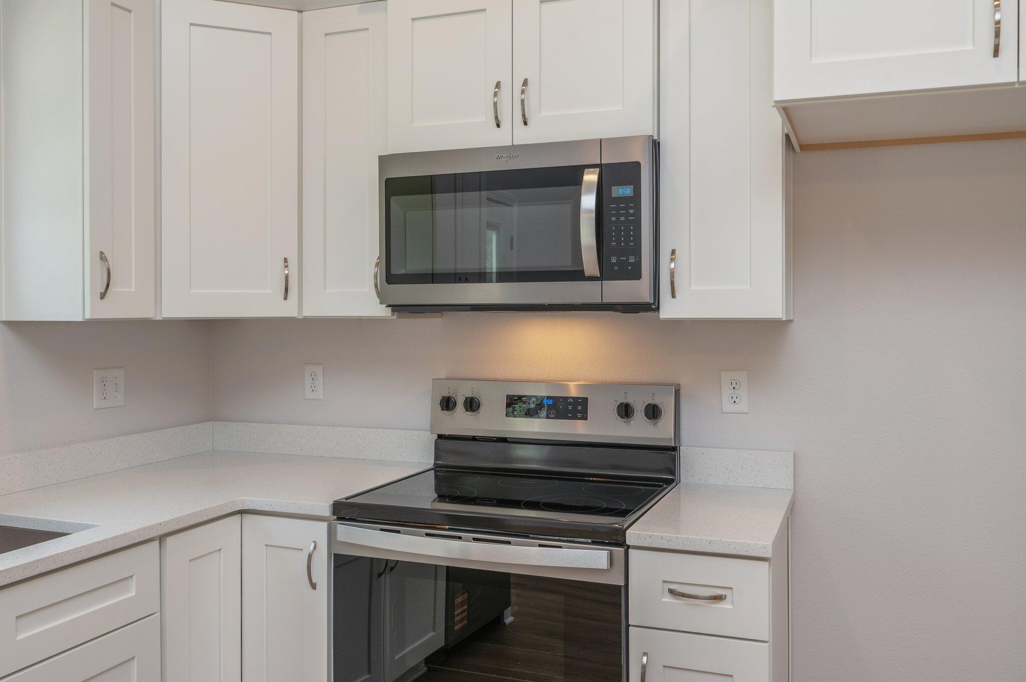 3929 Poverty Creek Road Crestview, FL 32539 - Photo 15 of 37 a kitchen with a stove and white cabinets