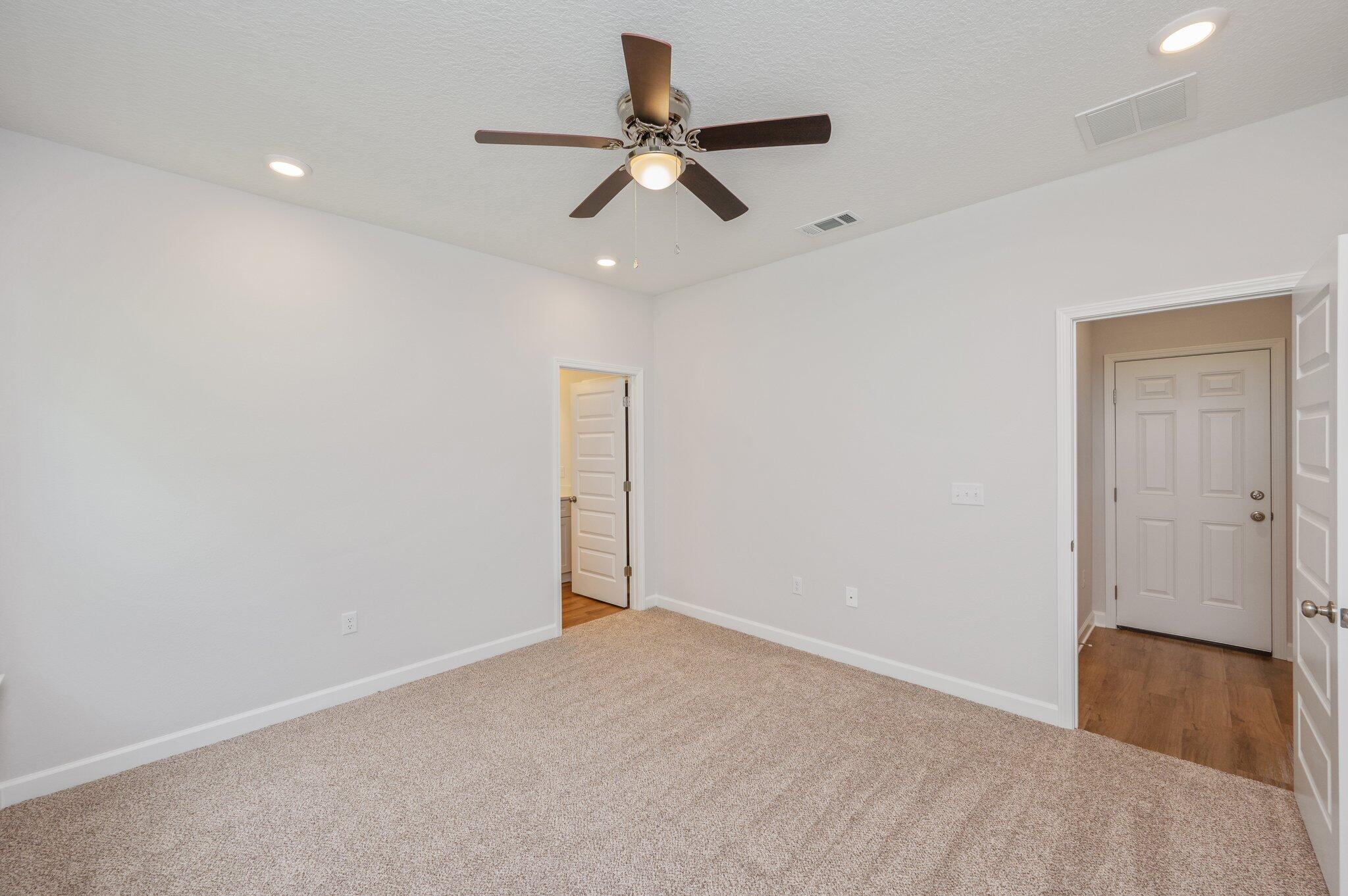 3929 Poverty Creek Road Crestview, FL 32539 - Photo 18 of 37 an empty room with wooden floor ceiling fan and windows