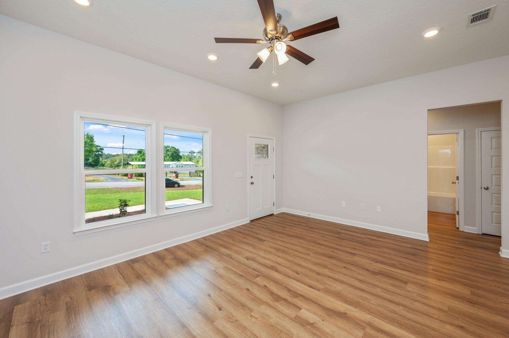 3929 Poverty Creek Road Crestview, FL 32539 - Photo 9 of 37 an empty room with wooden floor and windows