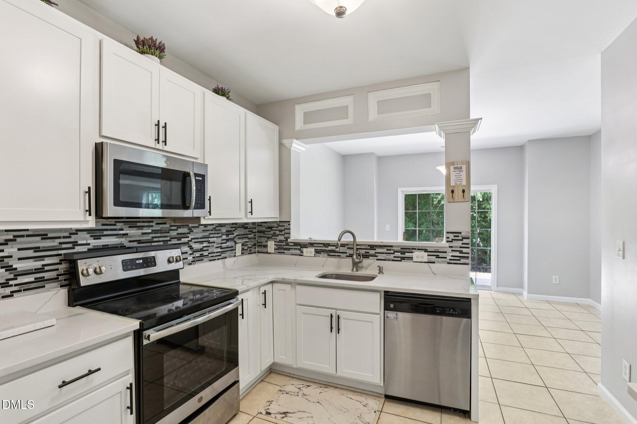 1212 Southgate Drive Raleigh, NC 27610 - Photo 11 of 31 a kitchen with a sink stove and microwave
