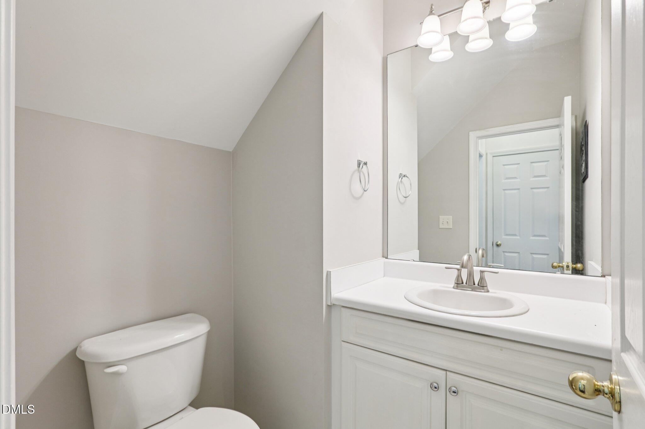 1212 Southgate Drive Raleigh, NC 27610 - Photo 12 of 31 a bathroom with a toilet a sink and mirror