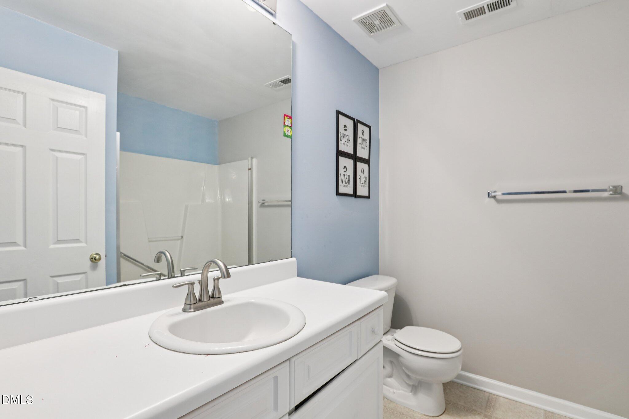 1212 Southgate Drive Raleigh, NC 27610 - Photo 21 of 31 a bathroom with a sink a toilet and mirror