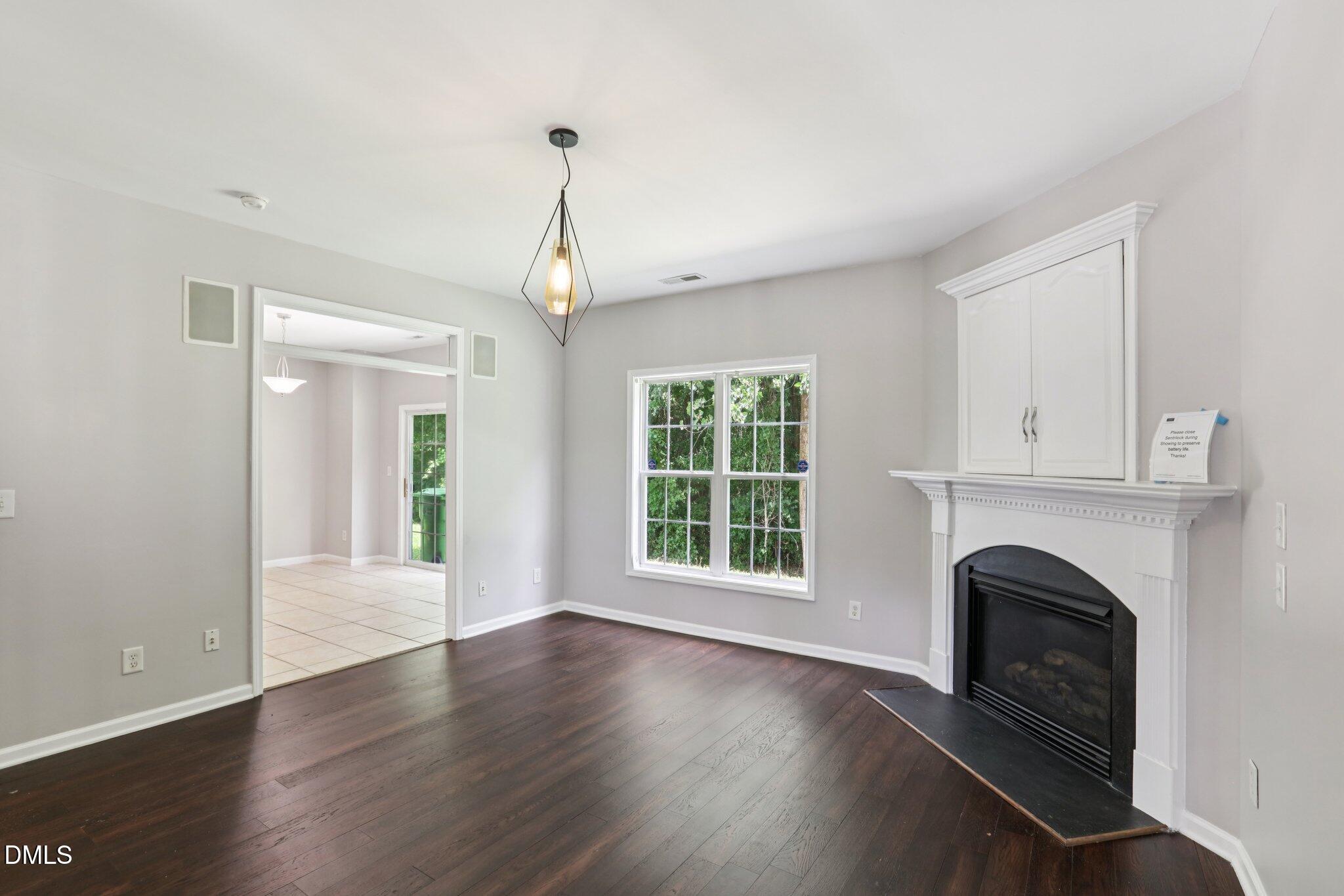 1212 Southgate Drive Raleigh, NC 27610 - Photo 6 of 31 a view of an empty room with wooden floor fireplace and a window