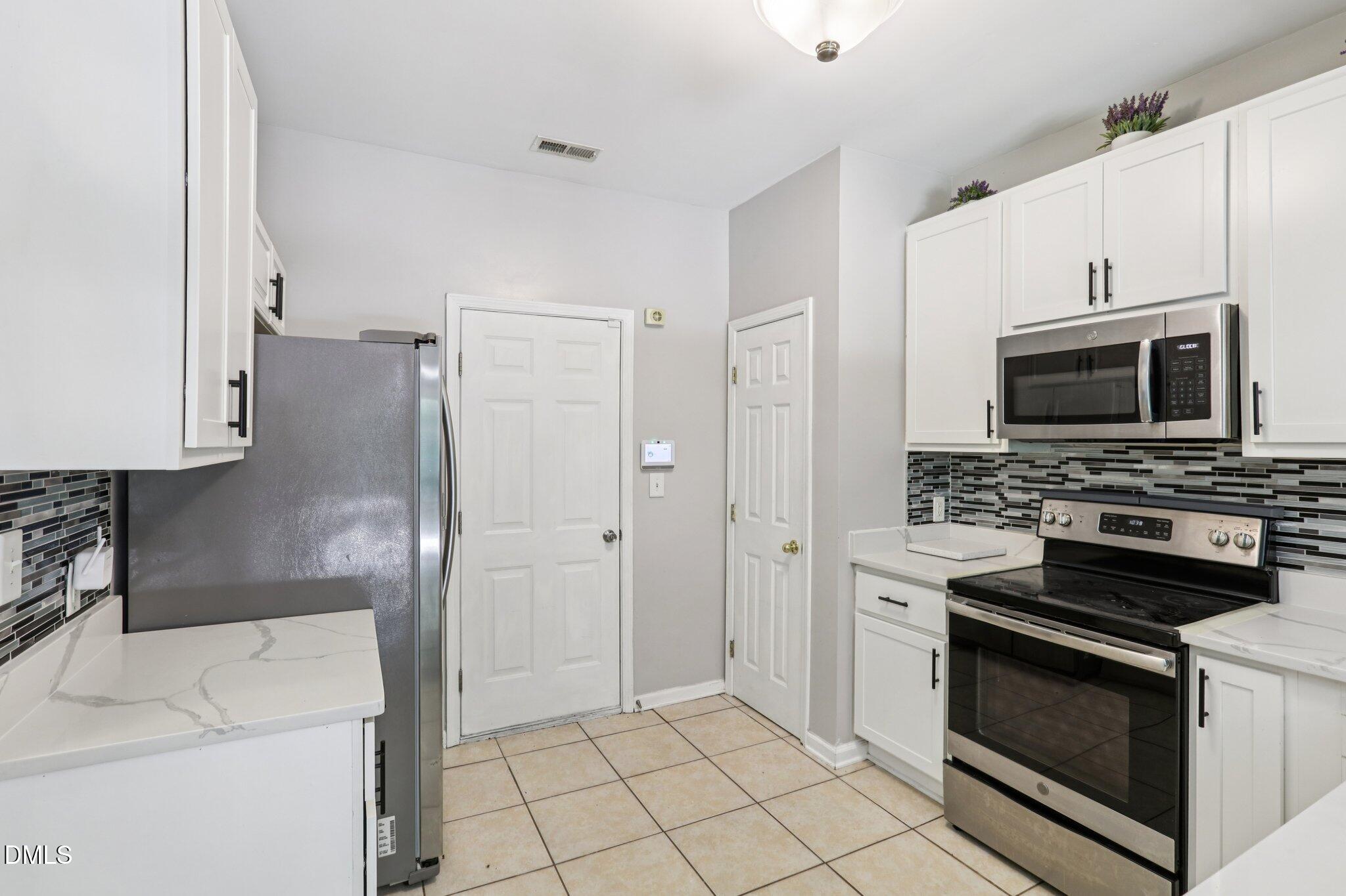 1212 Southgate Drive Raleigh, NC 27610 - Photo 10 of 31 a kitchen with a stove microwave and refrigerator